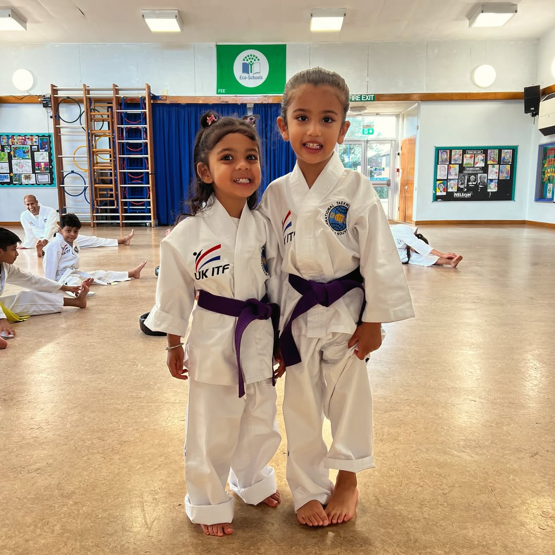 Two young Team Sidhu students smiling in their doboks